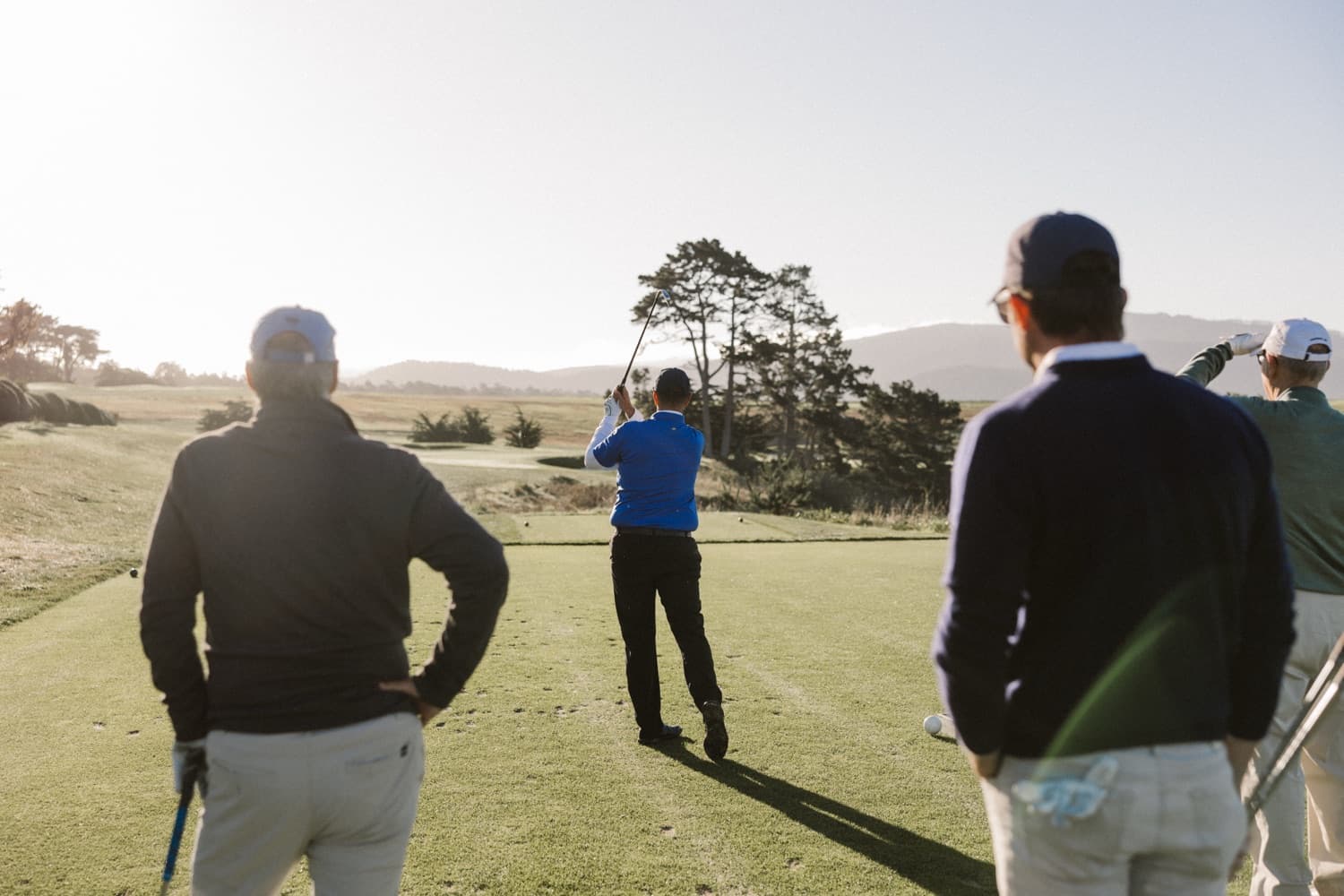 Executives on the course at sunset during a leadership golf event