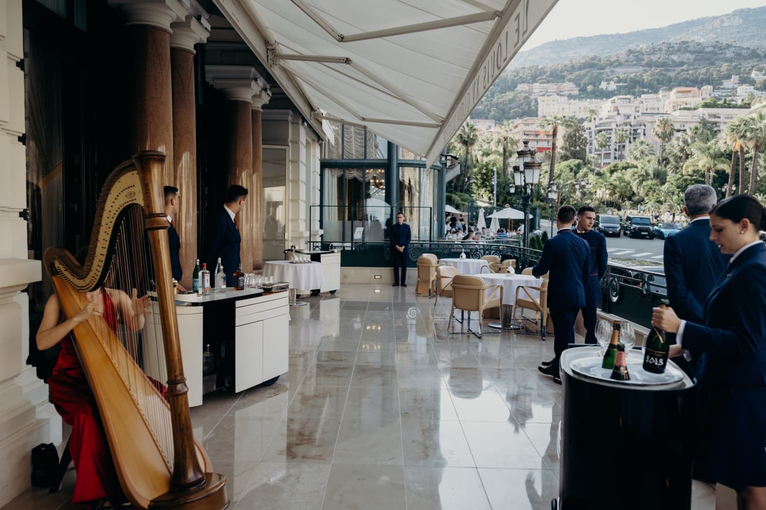A harpist and champagne service welcoming guests on a terrace